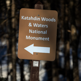 A brown sign that says Katahdin Woods and Waters National Monument.